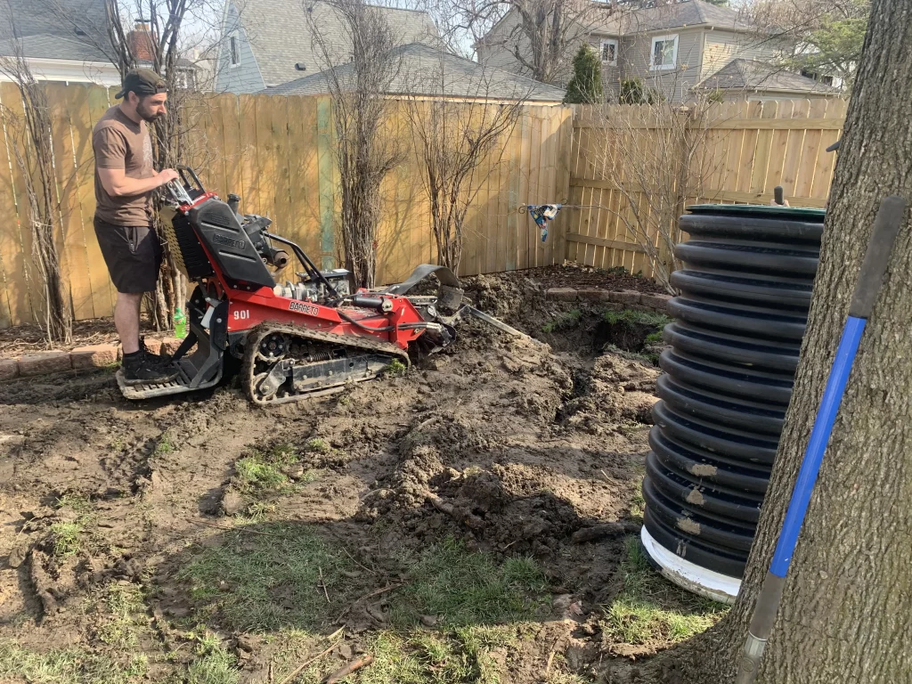 Residential backyard drainage system installation in Michigan with excavation and catch basin