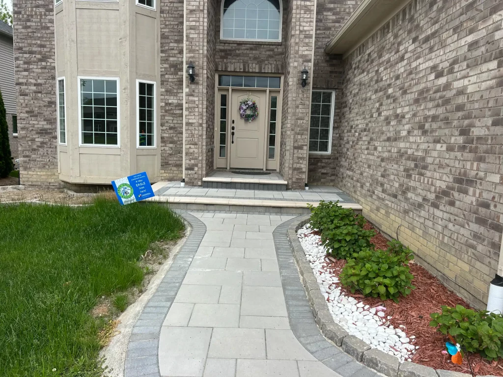 Brick paver walkway extending along the side of a home