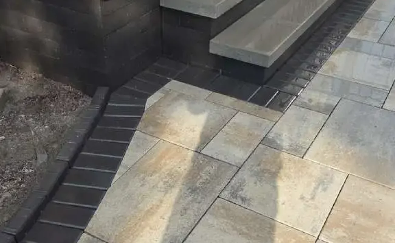 Landscape restoration project in Bloomfield Hills featuring rebuilt paver patio and structural retaining wall
